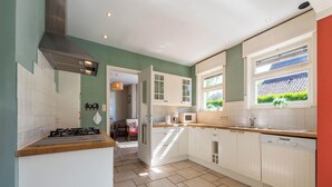 A modern kitchen with white cabinets, a stove, and a dishwasher.