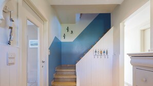 A staircase with blue walls and a white door on the left.