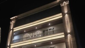 Ein mehrstöckiges Hotel mit einem imposanten Eingang, Balkonen und einer Treppe, die zum Eingang führt.