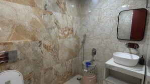 Ein Badezimmer mit Toilette, Waschbecken, Spiegel und Marmorwänden.