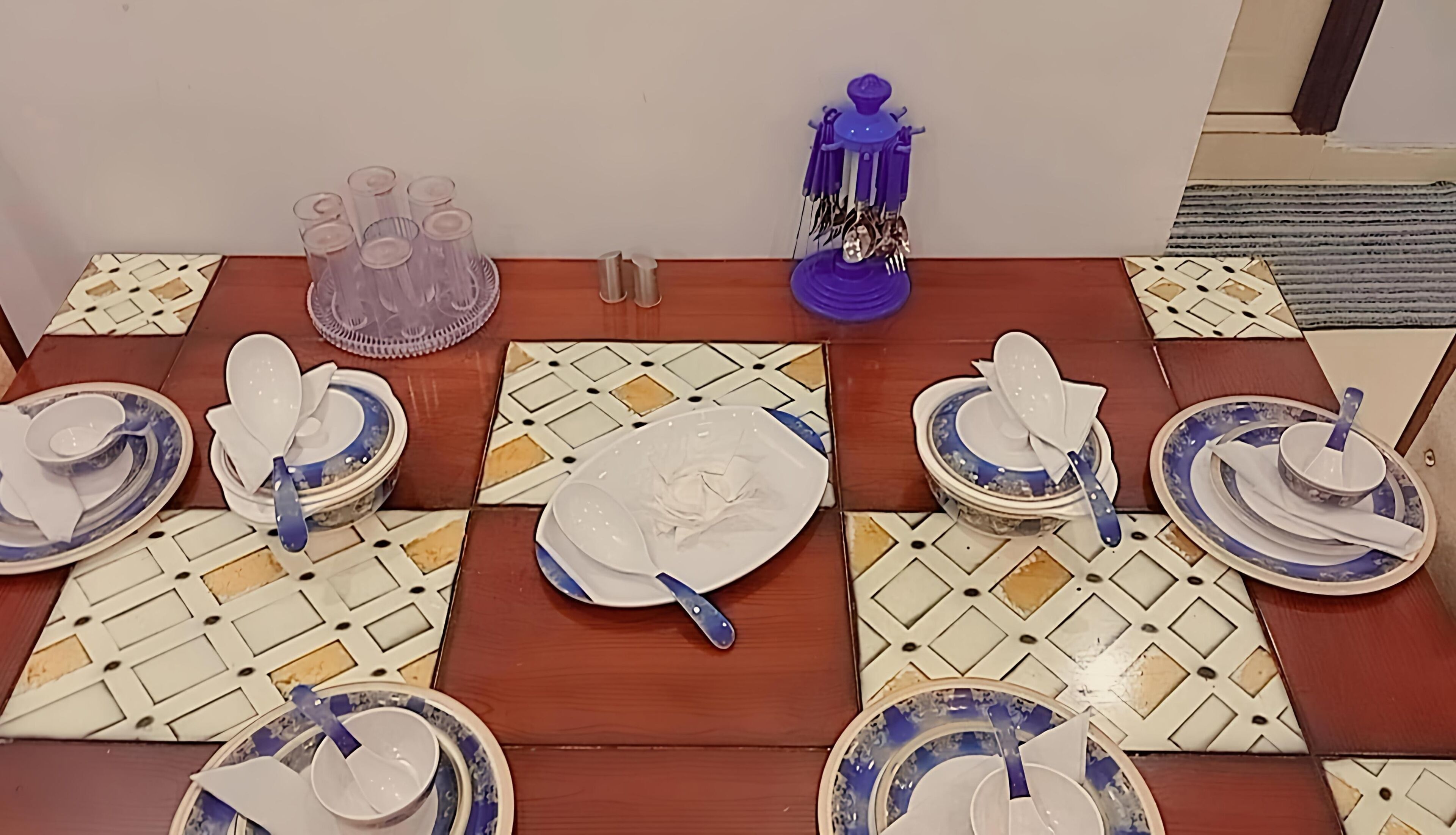 Zona de dinar amb taula de fusta i terres de rajola amb disseny.