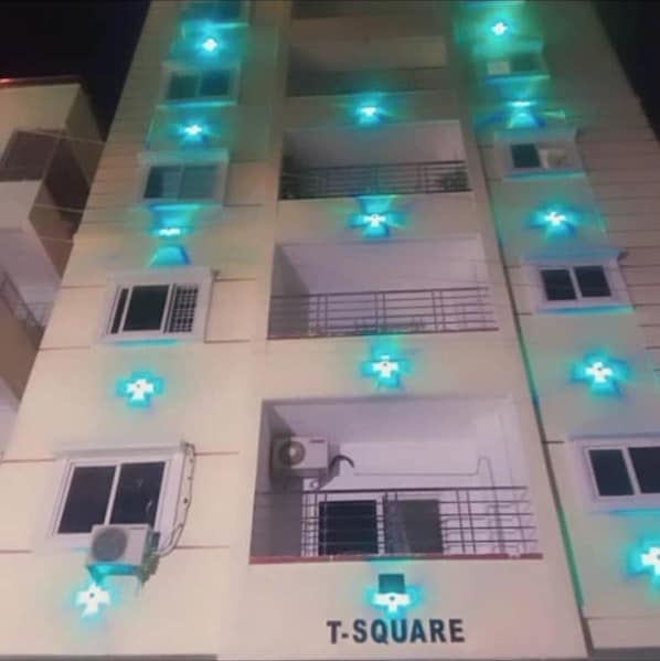 A building with multiple floors, each with a balcony and a window. The building is labeled "T-SQUARE".