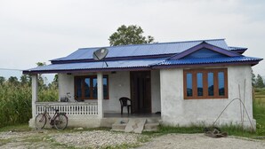 Ein einstöckiges Haus mit blauem Dach und weißen Wänden.