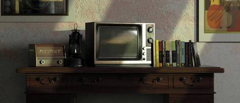 A wooden desk with a vintage radio, a lantern, and a microwave.