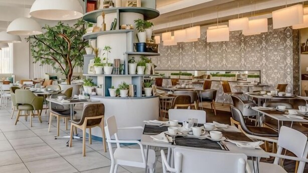 Un restaurant moderne avec des tables rondes, des chaises et une structure décorative centrale agrémentée de plantes.