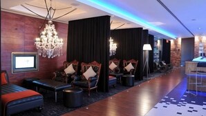 Un hall d’hôtel avec des sièges, un comptoir de réception et un lustre.
