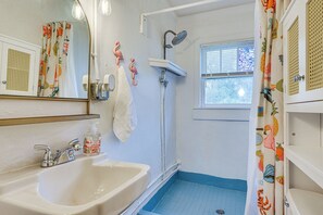 A bathroom with a white sink, a shower, and a window. - Little Cove Cottage! Walk to Dtwn Panama City (Panama City)