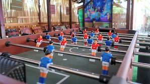 A foosball table with multiple players in red and blue uniforms. - Garpeza Backpackers (San Vicente)