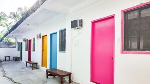 A row of colorful doors with benches in front, suggesting a waiting area or lobby. - Garpeza Backpackers (San Vicente)