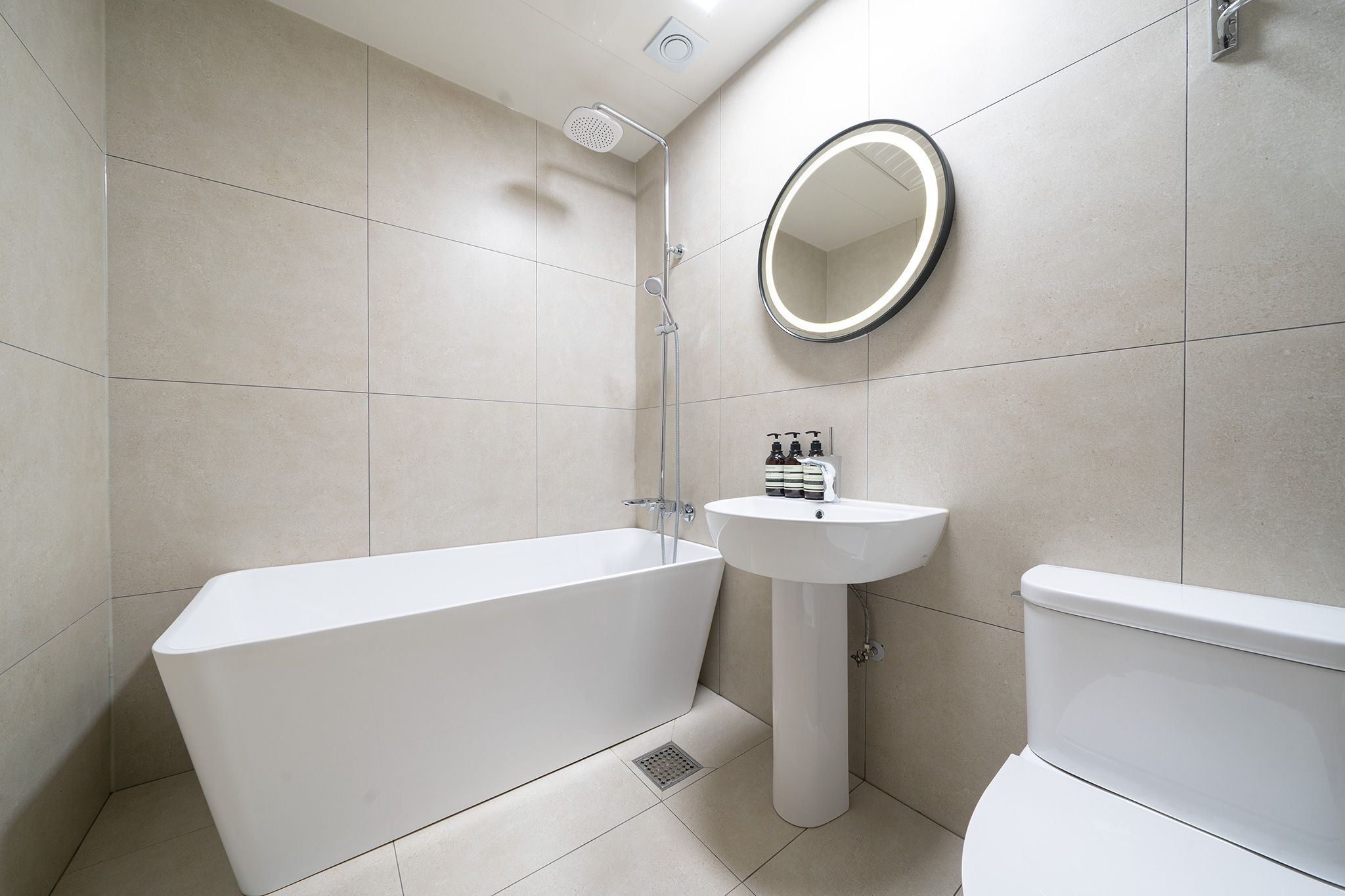 A modern bathroom with a bathtub, sink, and toilet.