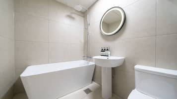 A modern bathroom with a bathtub, sink, and toilet.