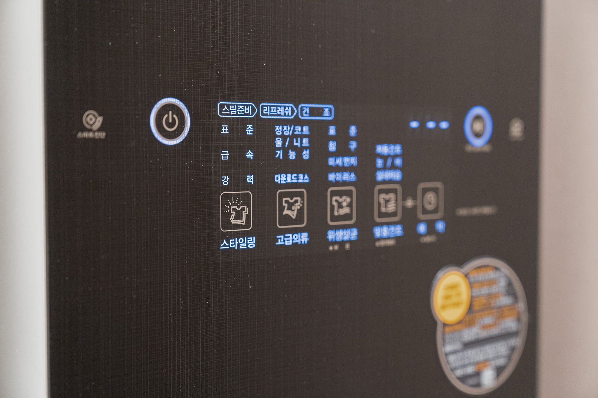 Un panel de control con varios botones e íconos, incluyendo un botón de encendido, navegación de menú y opciones de configuración.