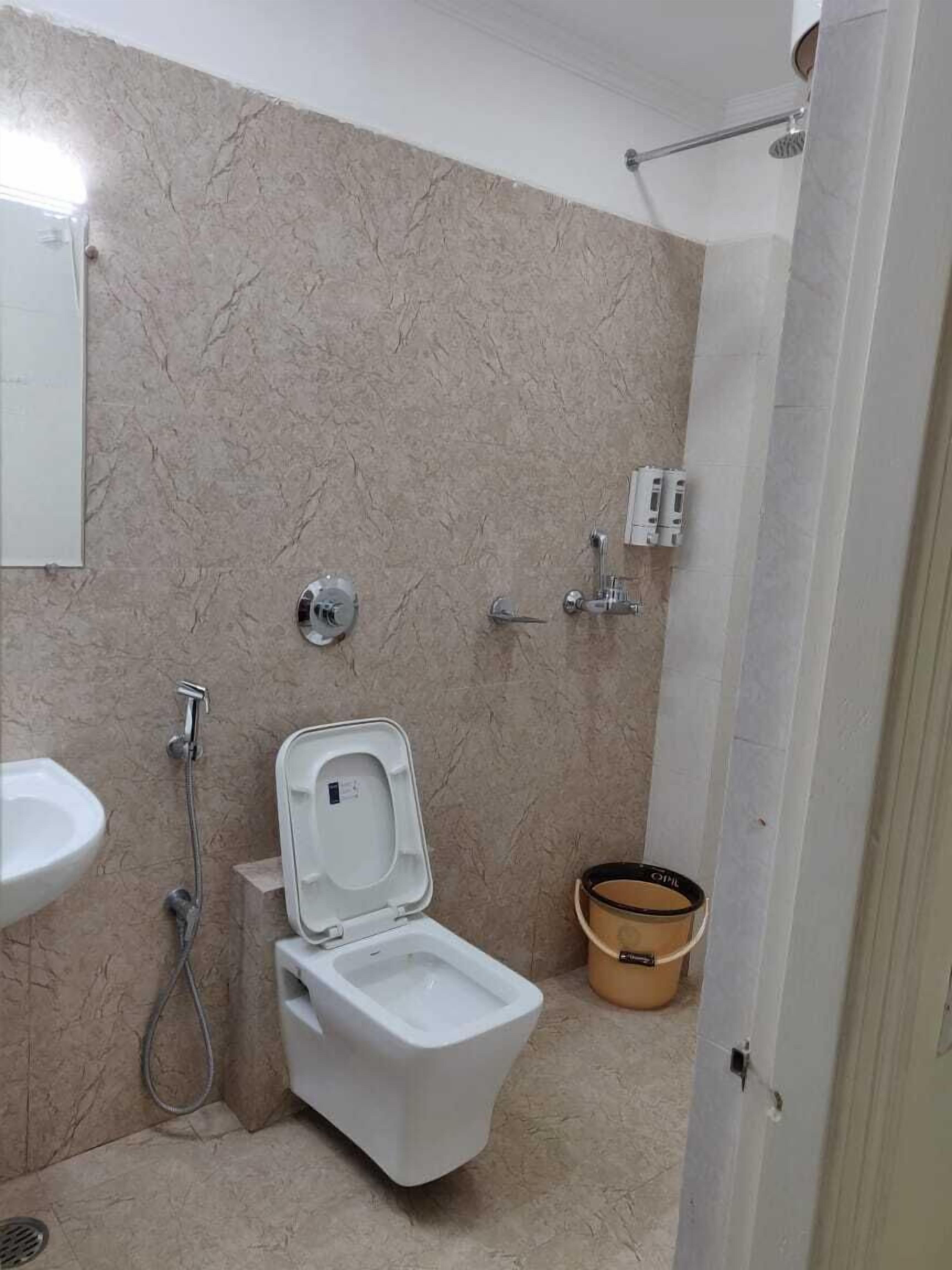 Een badkamer met toilet, bidet en douche.
