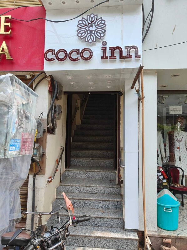A staircase leading to a Coco Inn entrance, with a motorcycle parked outside. - Coco Inn Homestay  (Varanasi)