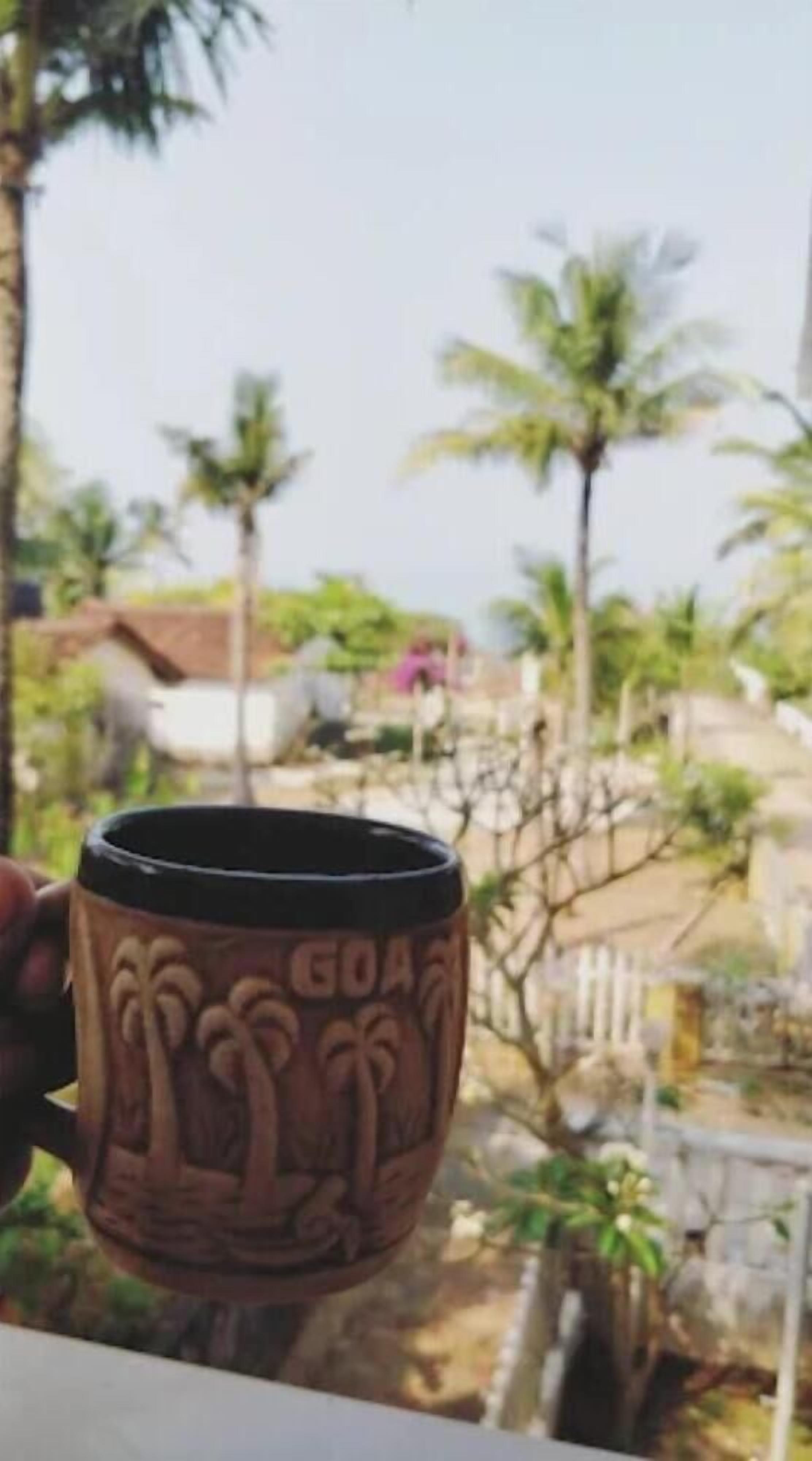 A mug with palm tree designs and the word "GOA" on it.
