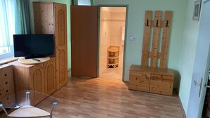 A room with wooden furniture, a television, and a door leading to a bathroom. - Waldrestaurant Vida  (Kapfenberg)