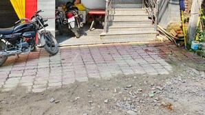 Entrada de um edifício com escadaria que leva a um andar superior. Motocicletas estão estacionadas do lado de fora, e um letreiro indica quartos, restaurante, salão de festas e salão para gatos.