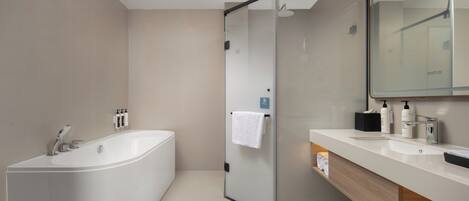 A modern bathroom with a freestanding bathtub, a glass shower enclosure, and a vanity with a mirror.