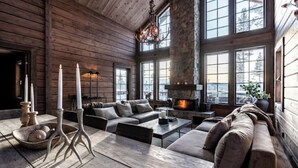 Une pièce spacieuse avec une grande cheminée, des murs en bois et un coin salon confortable.