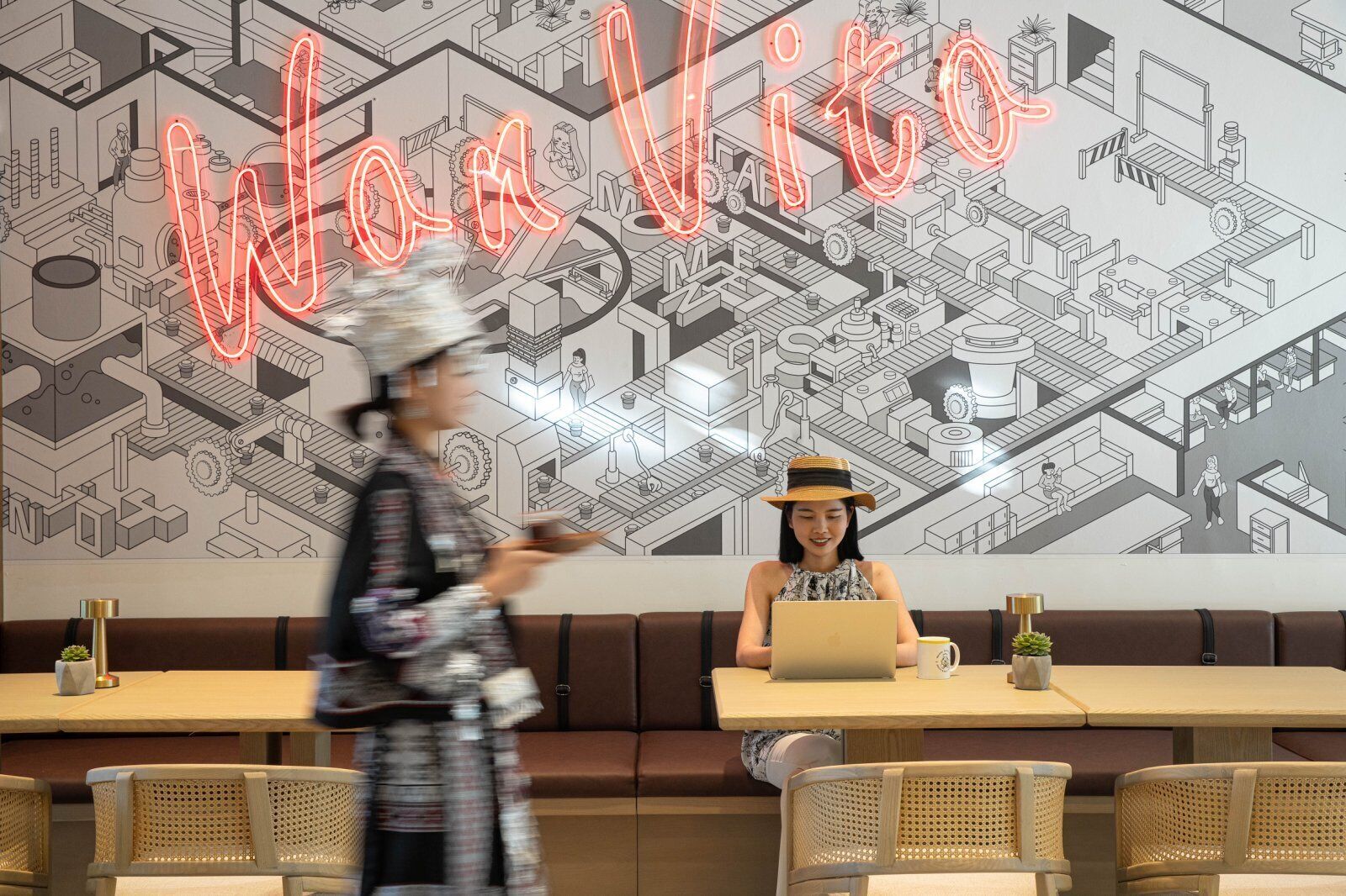 Un restaurante con un letrero de neón que dice "Wow Vito" y una gran ilustración isométrica en la pared.