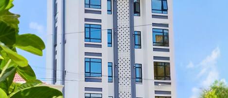 Un moderno edificio de hotel con varios pisos, grandes ventanas y un letrero que indica que es un hotel.