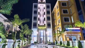 Un hôtel au design moderne, doté d’une entrée imposante et d’une enseigne en langue étrangère.