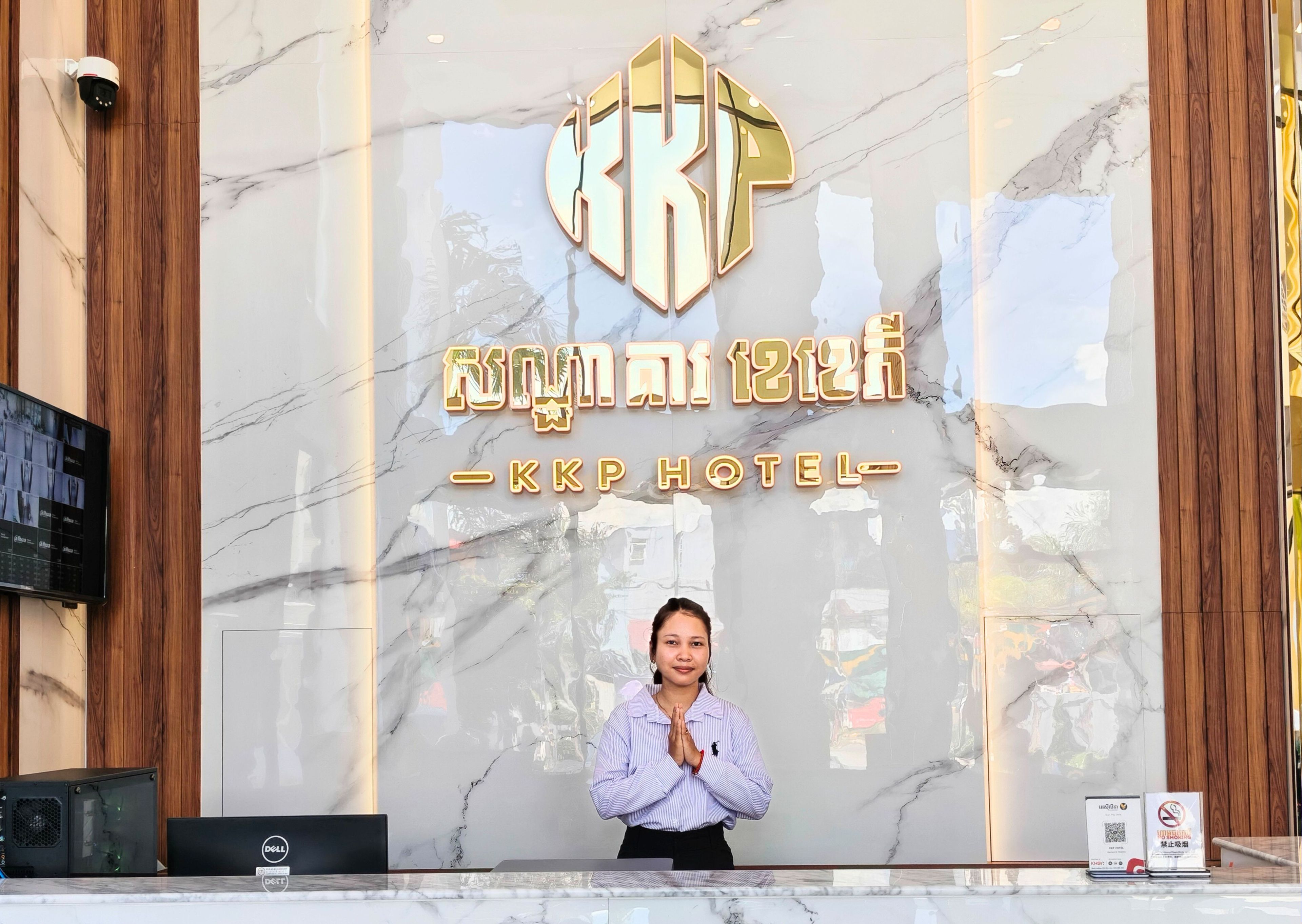 Un mostrador de recepción de hotel con una pared de mármol y un cartel grande que dice "KKP HOTEL".