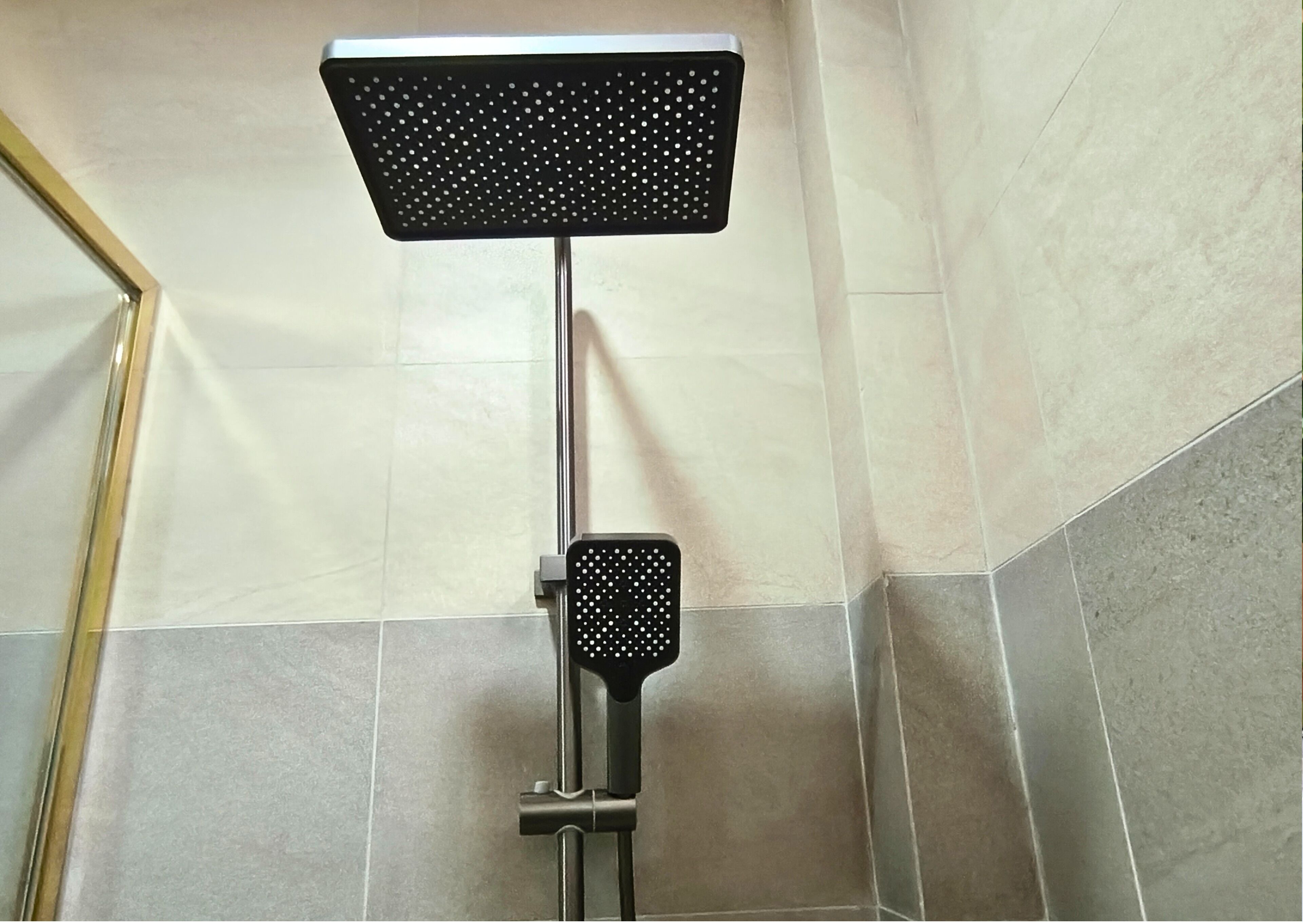 Eine Dusche mit Duschkopf und Handbrause.