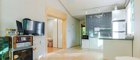 Una cocina moderna con refrigerador, microondas y pileta.
