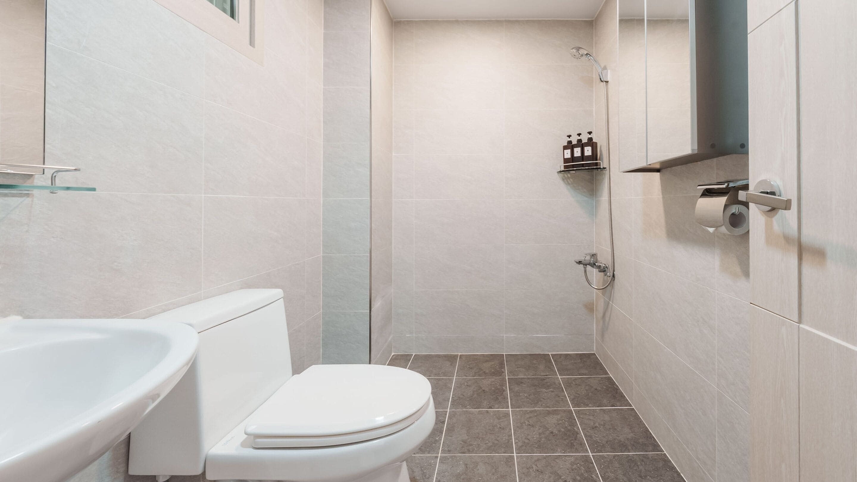 Un baño moderno con inodoro, lavamanos y ducha.