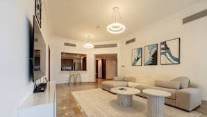 A modern living room with a sofa, two coffee tables, and artwork on the wall.
