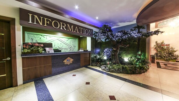 A hotel reception area with a reception desk, a 'MU HOTEL' sign, and a decorative indoor garden. - From H Amoremio The Classic Suwon (Suwon)