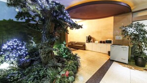 A hotel lobby with a reception desk, a sofa, and a kitchenette area. - From H Amoremio The Classic Suwon (Suwon)