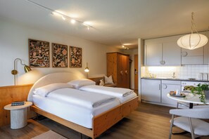 Un dormitorio moderno con una cama de madera, lámparas de noche y una obra de arte en la pared.