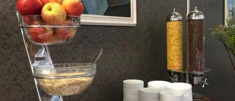 Disposición de buffet con frutero, cereales y salsas.