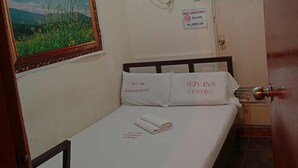 A single bed with white bedding and pillows labeled "WJV INN MANDALUE CENTRO". A no smoking sign is visible on the wall. - WJV INN MANDAUE CENTRO (Mandaue)
