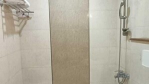 A bathroom with a bathtub, toilet, and shower. - Roomshala Hotel J JOy (New Delhi)