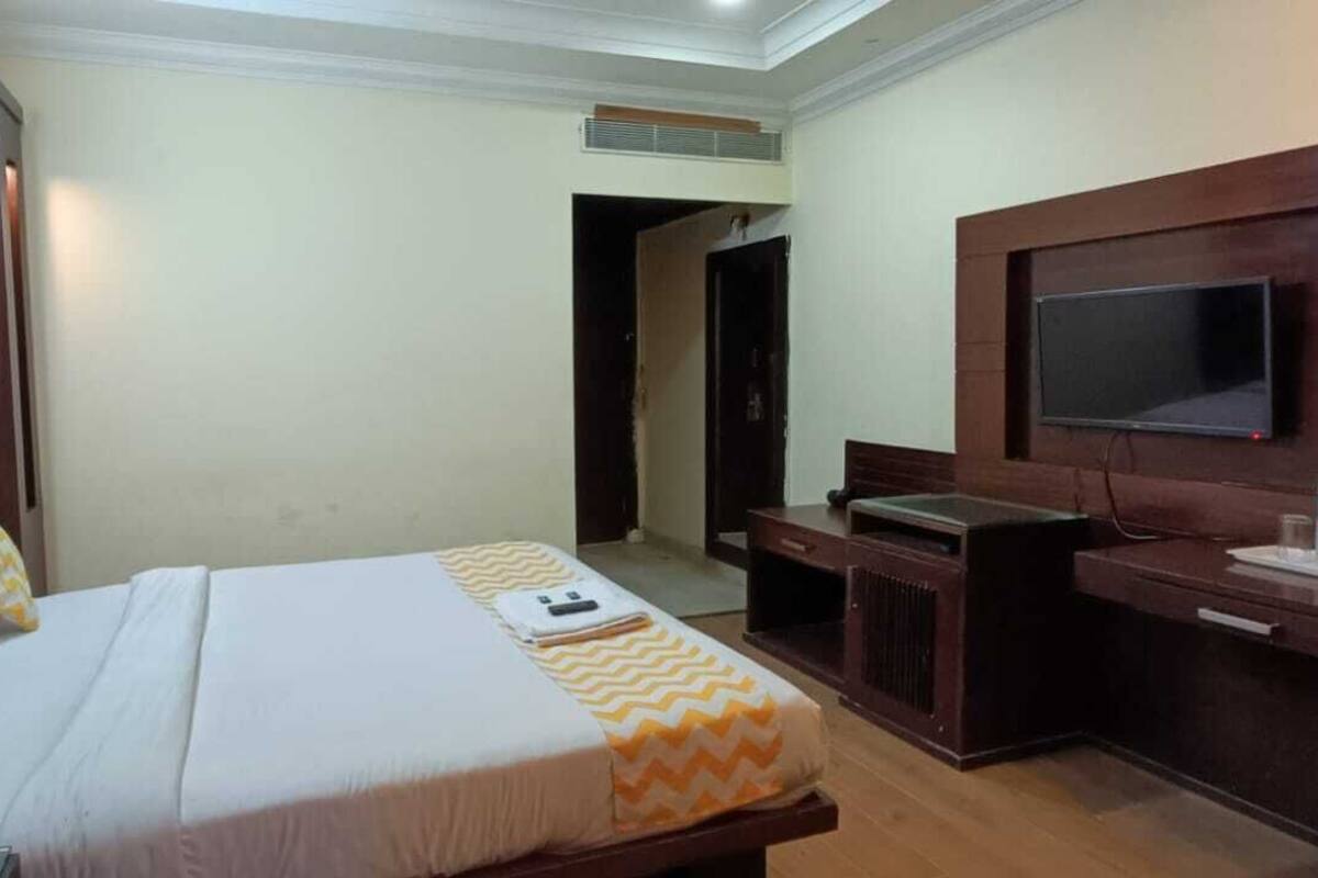 Ein Hotelzimmer mit Bett, Schreibtisch, Fernseher und Minibar.