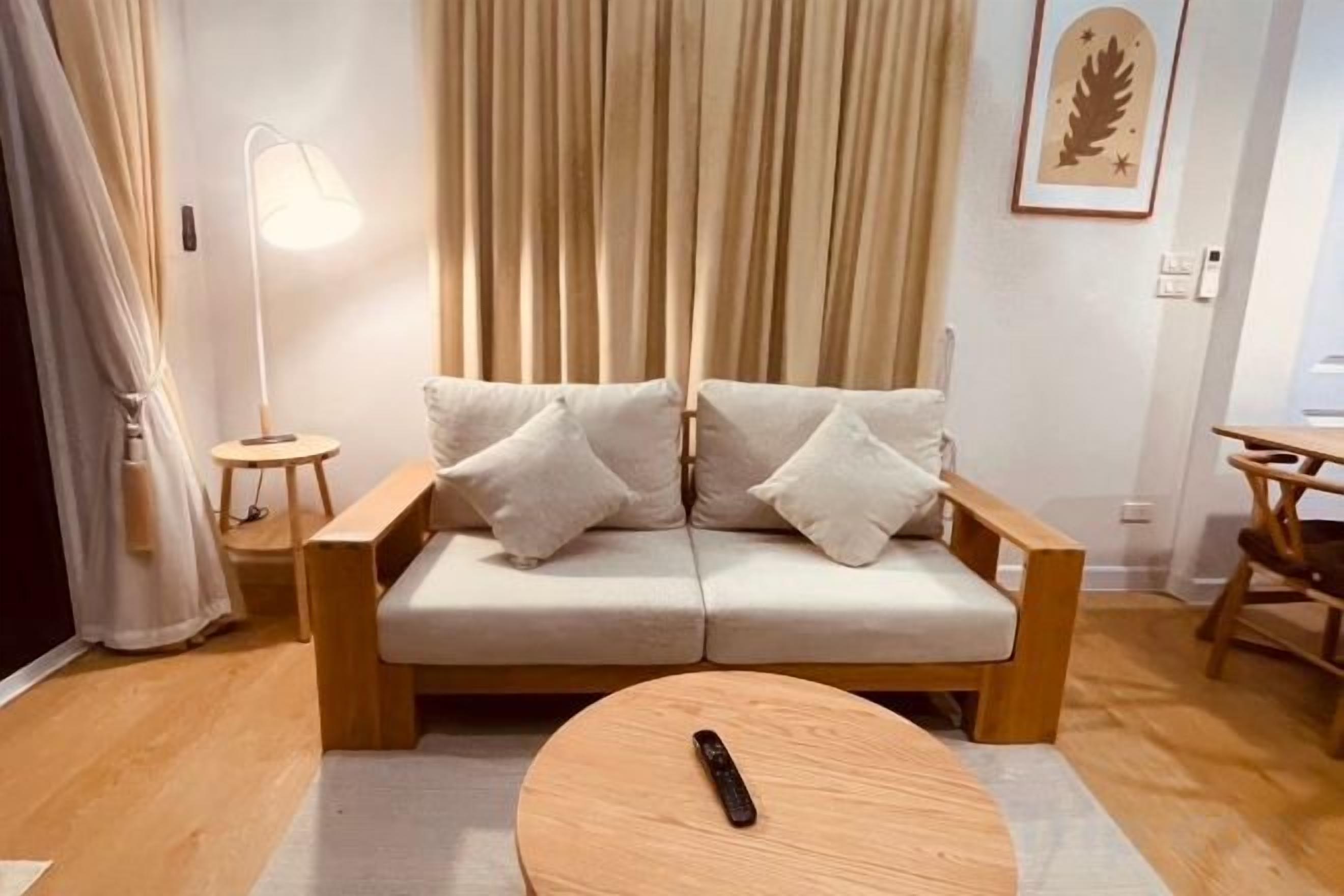 A modern living room with a sofa, a round coffee table, and a lamp.