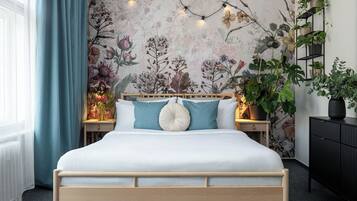 Een slaapkamer met een bed, nachtkastje, kaptafel en een wand met een bloemenreliëf.