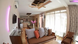 A living room with a sofa, chairs, a dining table, and a kitchen in the background. - Taurus Villa10 Bedrooms with Private Pool. (Pattaya)