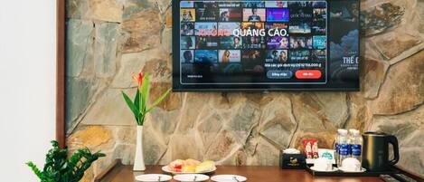 A television mounted on a stone wall displaying a movie selection.