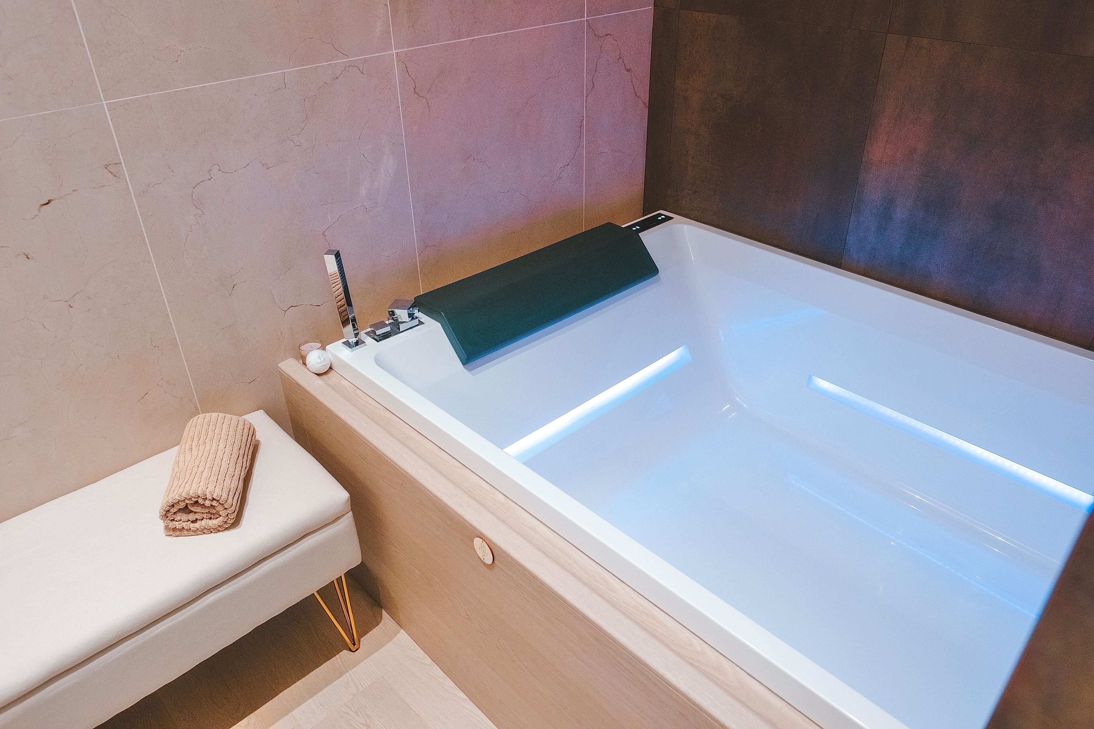Une salle de bain moderne avec une baignoire, des toilettes et une serviette posée sur les toilettes.