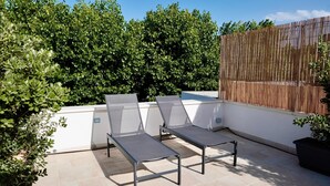 A rooftop terrace with two sun loungers and a potted plant. - 18zero2 Luxury Rooms (Bari)