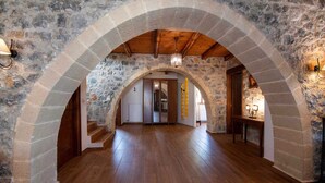 A spacious interior with stone walls, wooden floors, and a vaulted ceiling.