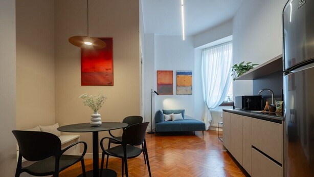 Un espace de vie compact comprenant un coin repas, une kitchenette et un canapé.