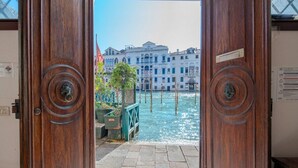 Uma porta de madeira com vista para um canal e prédios.