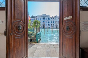 A wooden door with a view of a canal and buildings. - Ca' Marcello Levante (Venezia)