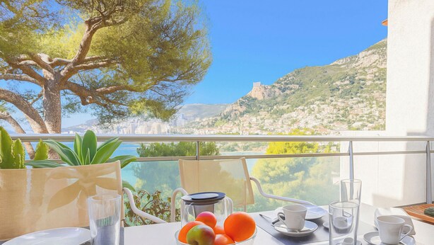 Una tavola apparecchiata per la colazione con vista sul paesaggio costiero.