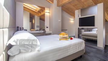 Ein modernes Schlafzimmer mit einem großen Bett, einem Fernseher und einem Frühstücksbrettchen.